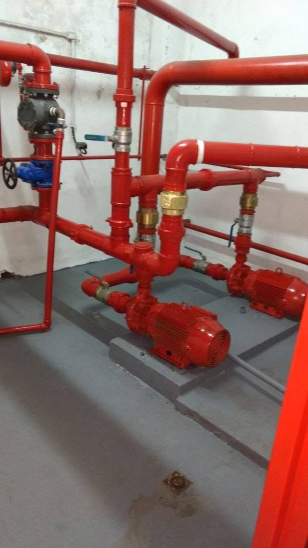 Casa de bombas com duas motobombas e barrilete pintado de vermelho